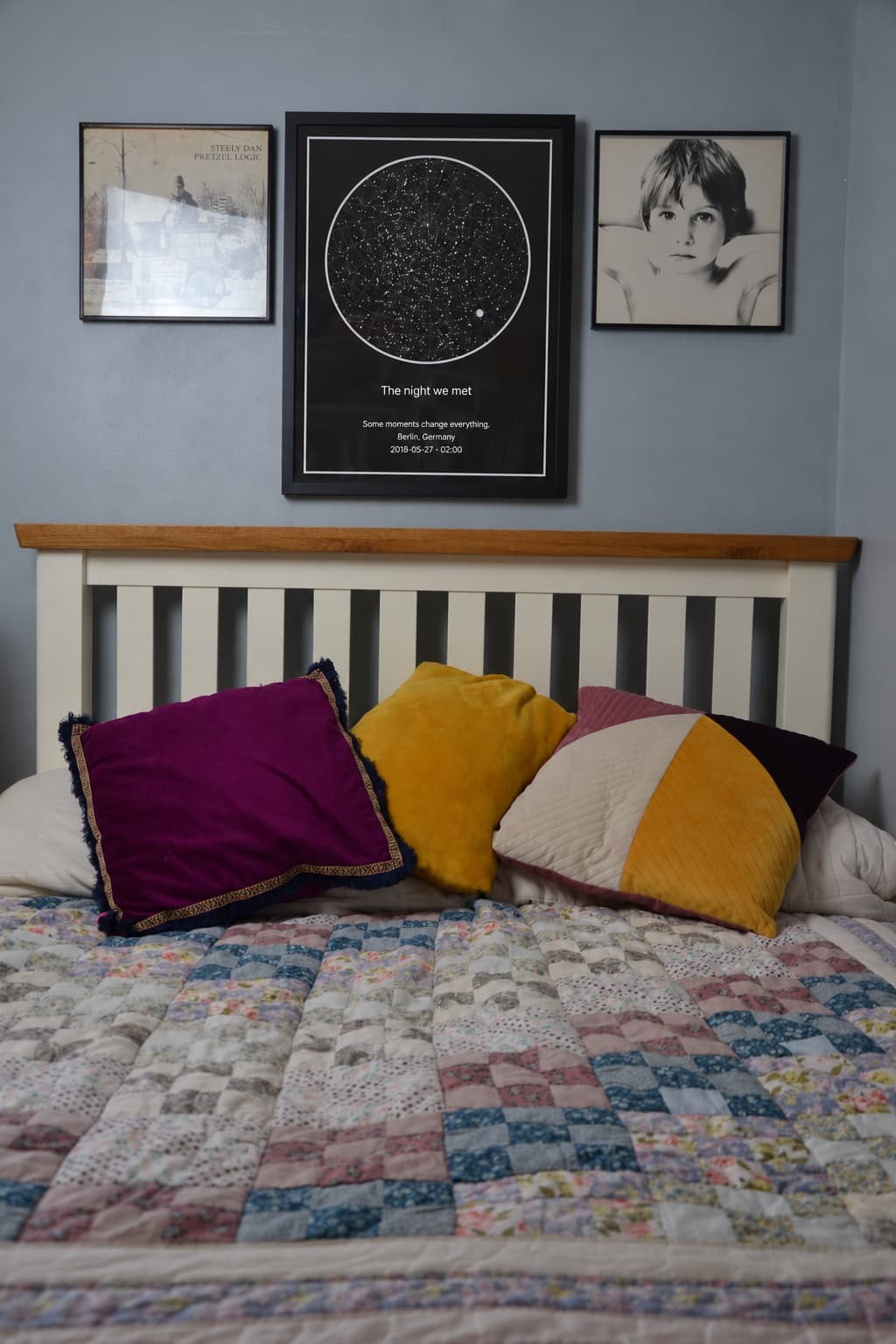 Framed star map hanging above a bed between two prints